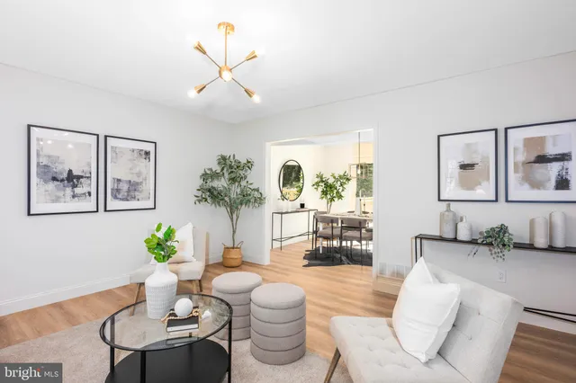 a living room with furniture flowers and a chandelier