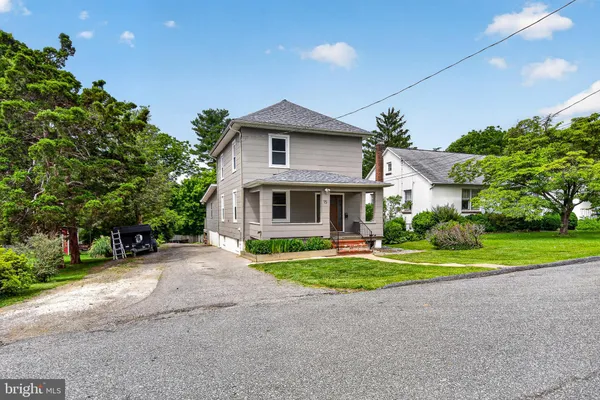 a front view of a house with a yard and trees