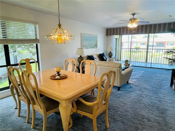 a view of a dining room with furniture a chandelier and wooden floor