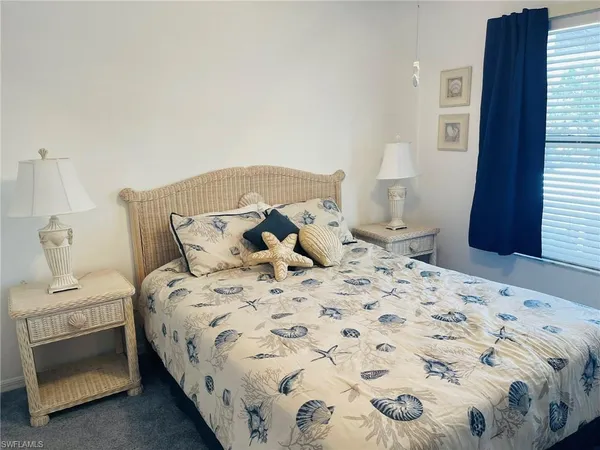 a large bed sitting in a bedroom next to a window and a bathroom