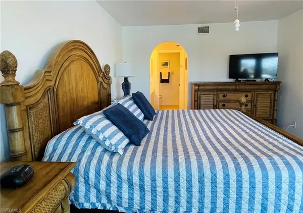 a bedroom with a bed and a flat screen tv