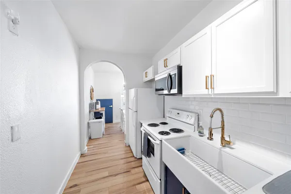 a kitchen with a sink a counter top space and cabinets