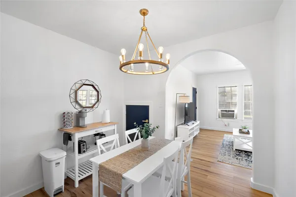 a view of a dining room with furniture a chandelier and wooden floor