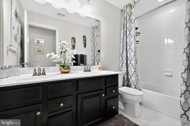 a bathroom with a double vanity sink toilet and shower