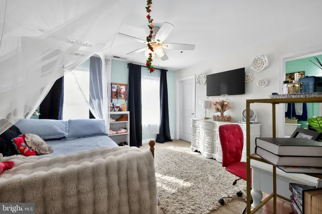 a bedroom with a bed couch and a flat tv screen