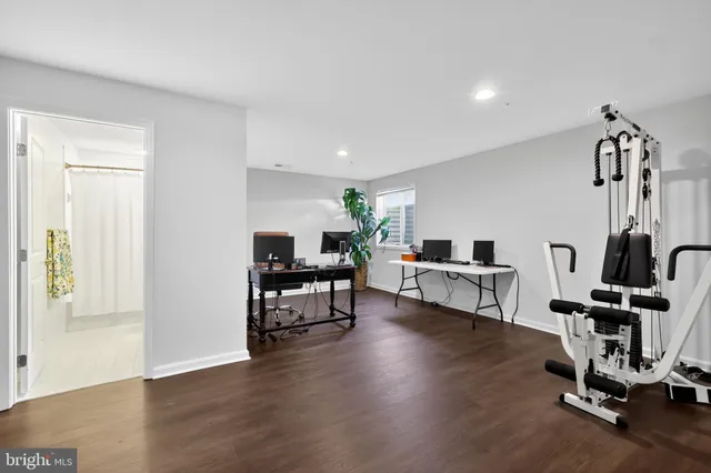 a living room with furniture gym equipment and wooden floor