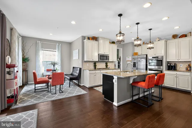 a large kitchen with a table chairs stove and wooden floor