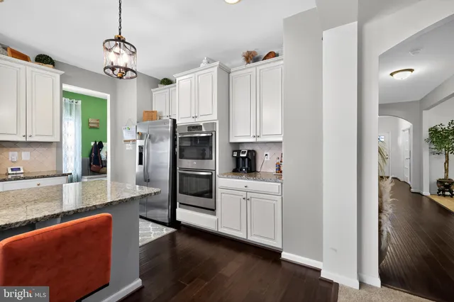 a kitchen with stainless steel appliances kitchen island granite countertop a refrigerator and microwave