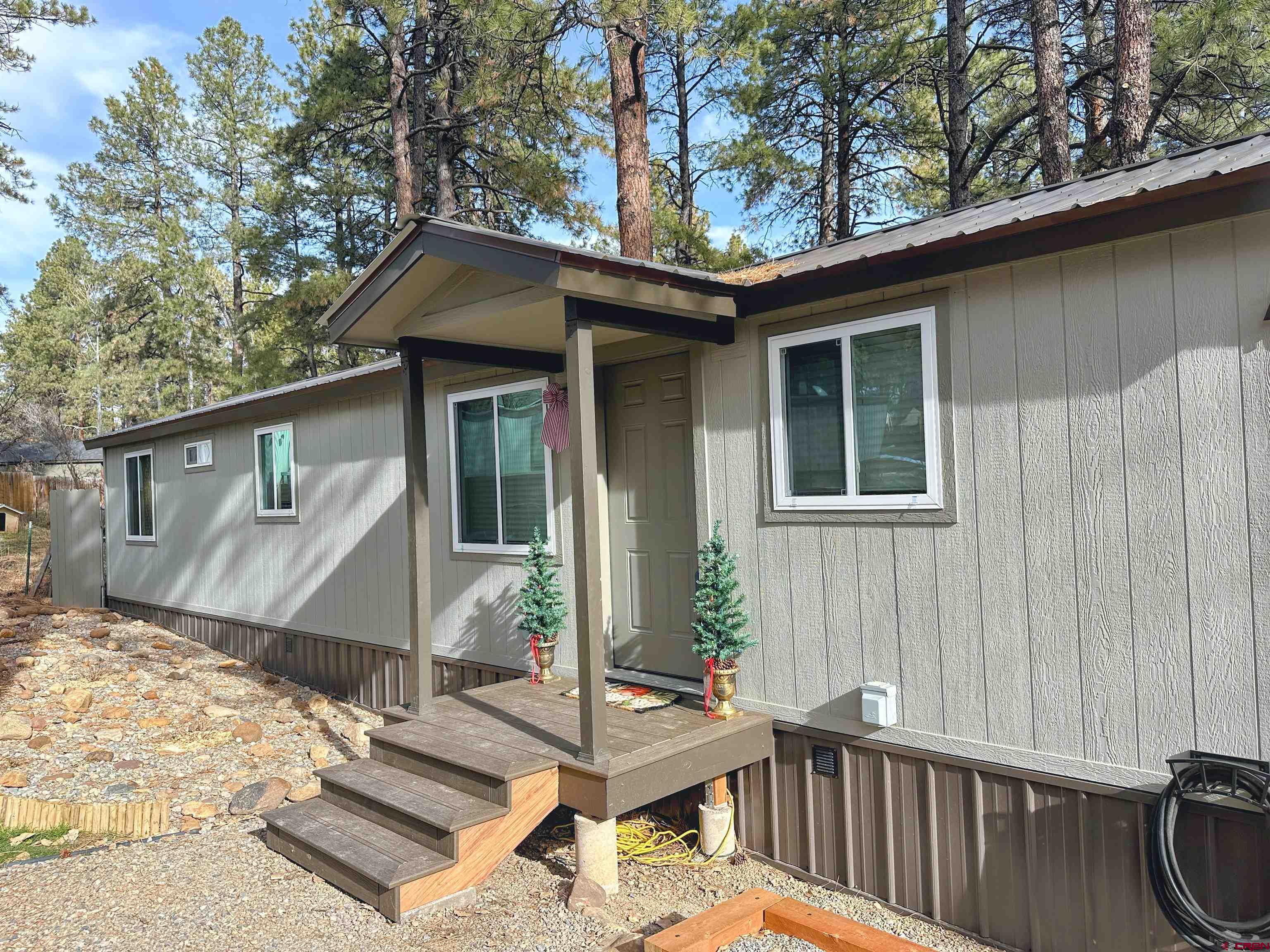 a view of a house with a small yard and wooden fence