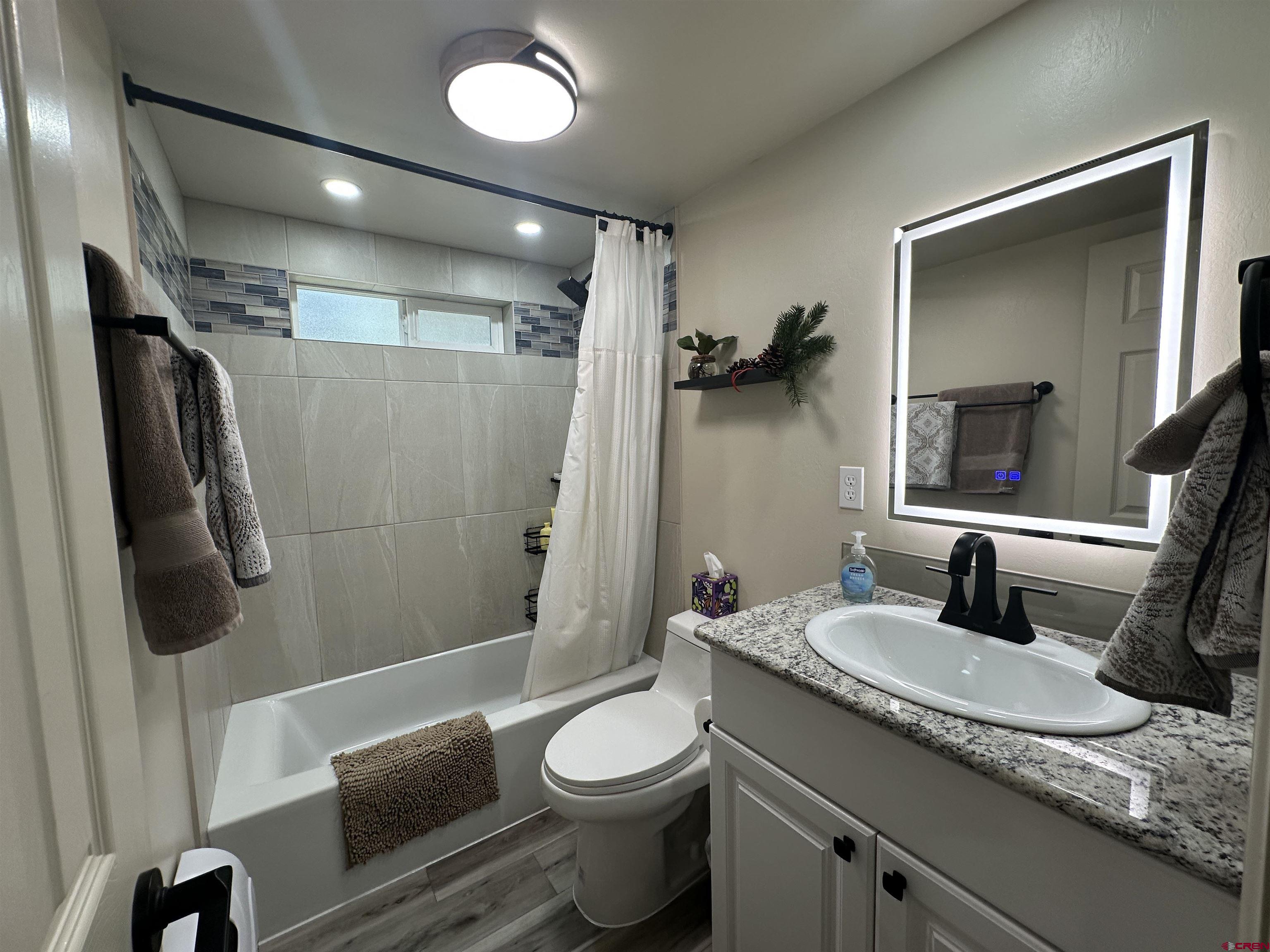 40 Hidden Lane Durango, CO 81303 - Photo 26 of 38 a bathroom with a granite countertop sink toilet and shower