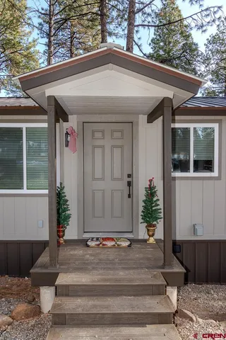 a kitchen with stainless steel appliances granite countertop a sink dishwasher a refrigerator a stove and a dining table with wooden floor