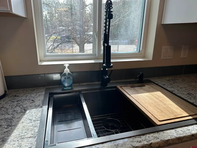 a bathroom with a granite countertop sink toilet and shower
