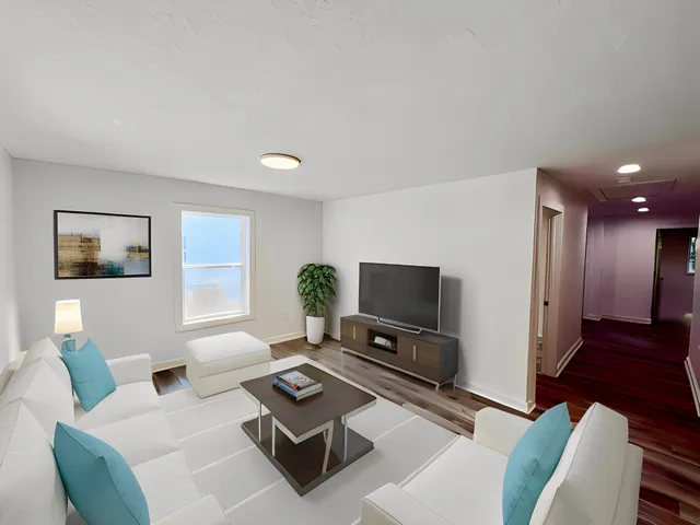 a living room with furniture a flat screen tv and a window