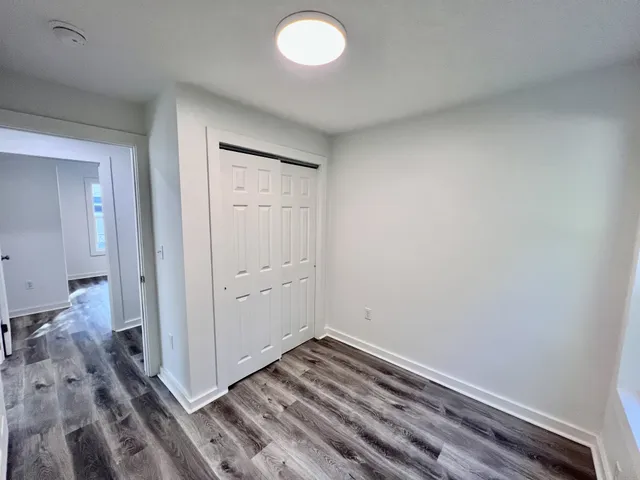 a view of a room with wooden floor and bedroom