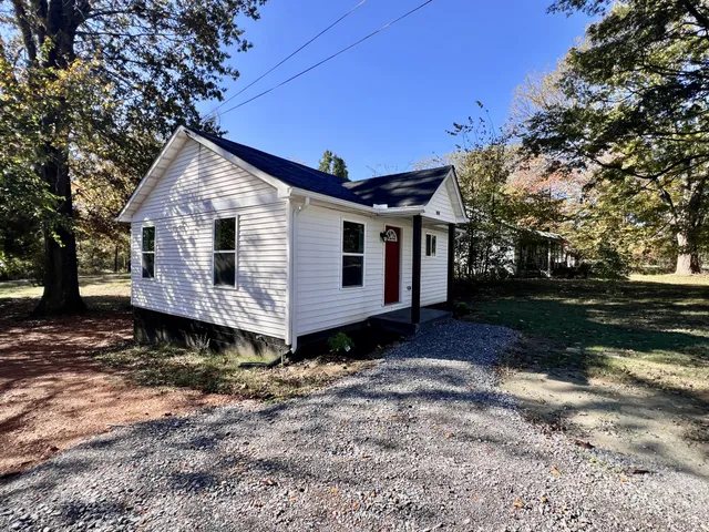 a view of a small house with a yard