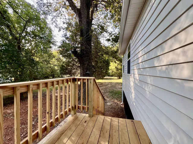 a view of balcony with wooden floor and fence