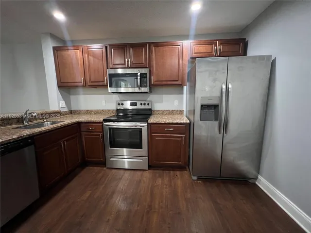 a kitchen with stainless steel appliances granite countertop a stove a sink dishwasher a refrigerator and a microwave oven