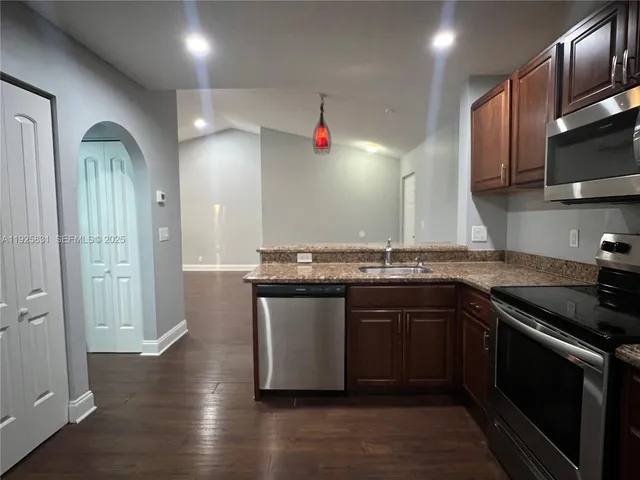 a kitchen with stainless steel appliances granite countertop a sink and a stove top oven
