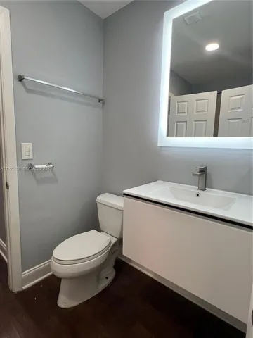 a bathroom with a toilet a sink and mirror