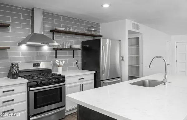 a kitchen with stainless steel appliances kitchen island a stove and a sink