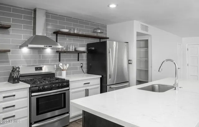 a kitchen with stainless steel appliances kitchen island a stove and a sink