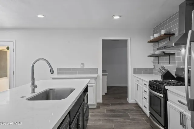 a kitchen with a sink stove top oven and refrigerator
