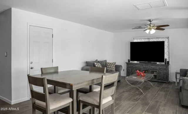 a view of a dining room with furniture wooden floor and a flat screen tv