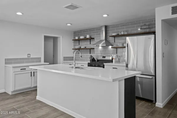 a kitchen with stainless steel appliances a sink and a refrigerator