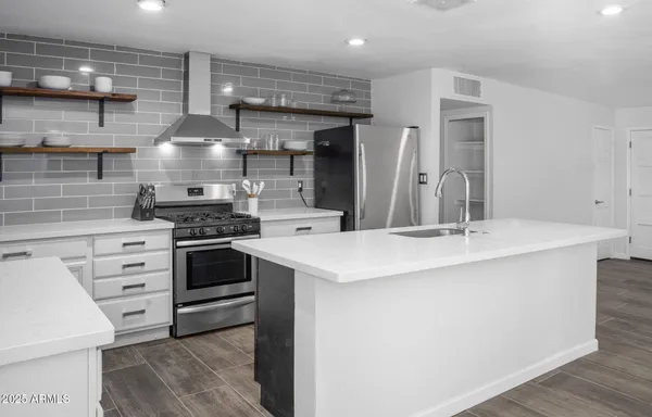 a kitchen with stainless steel appliances a stove and cabinets
