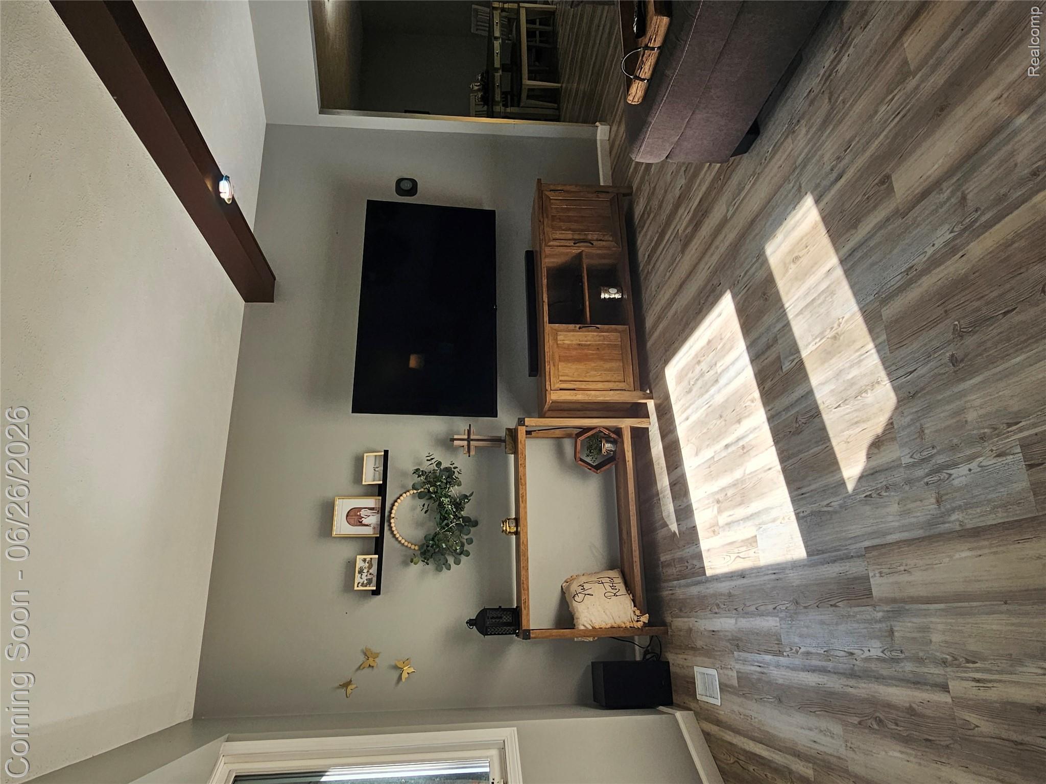 11211 Boyce Road Chelsea, MI 48118 - Photo 2 of 22 Spacious living area featuring wood-finish flooring, a neutral wall color, and white trim