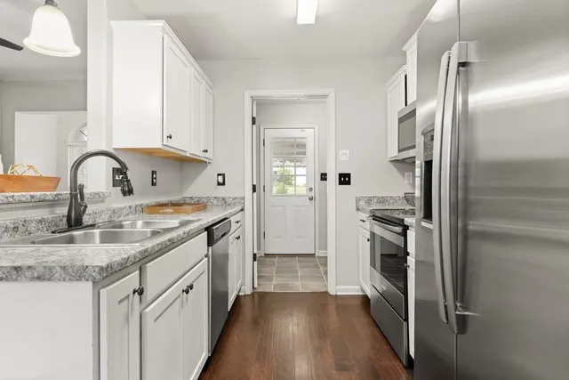 a kitchen with stainless steel appliances granite countertop a refrigerator and a sink