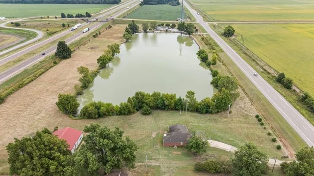 a view of a lake with a floor to ceiling window next to a yard