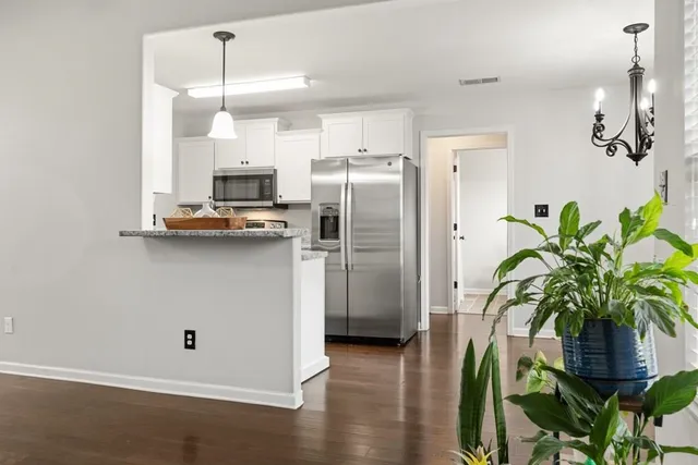 a kitchen with stainless steel appliances a refrigerator a sink a stove a cabinets and wooden floor