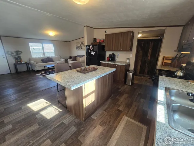 a large kitchen with stainless steel appliances granite countertop a lot of counter space and wooden floor