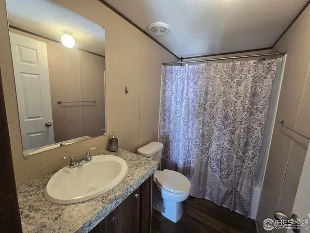 a bathroom with a granite countertop sink toilet and shower