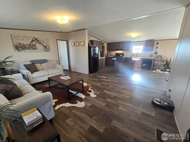 a living room with furniture and view of kitchen