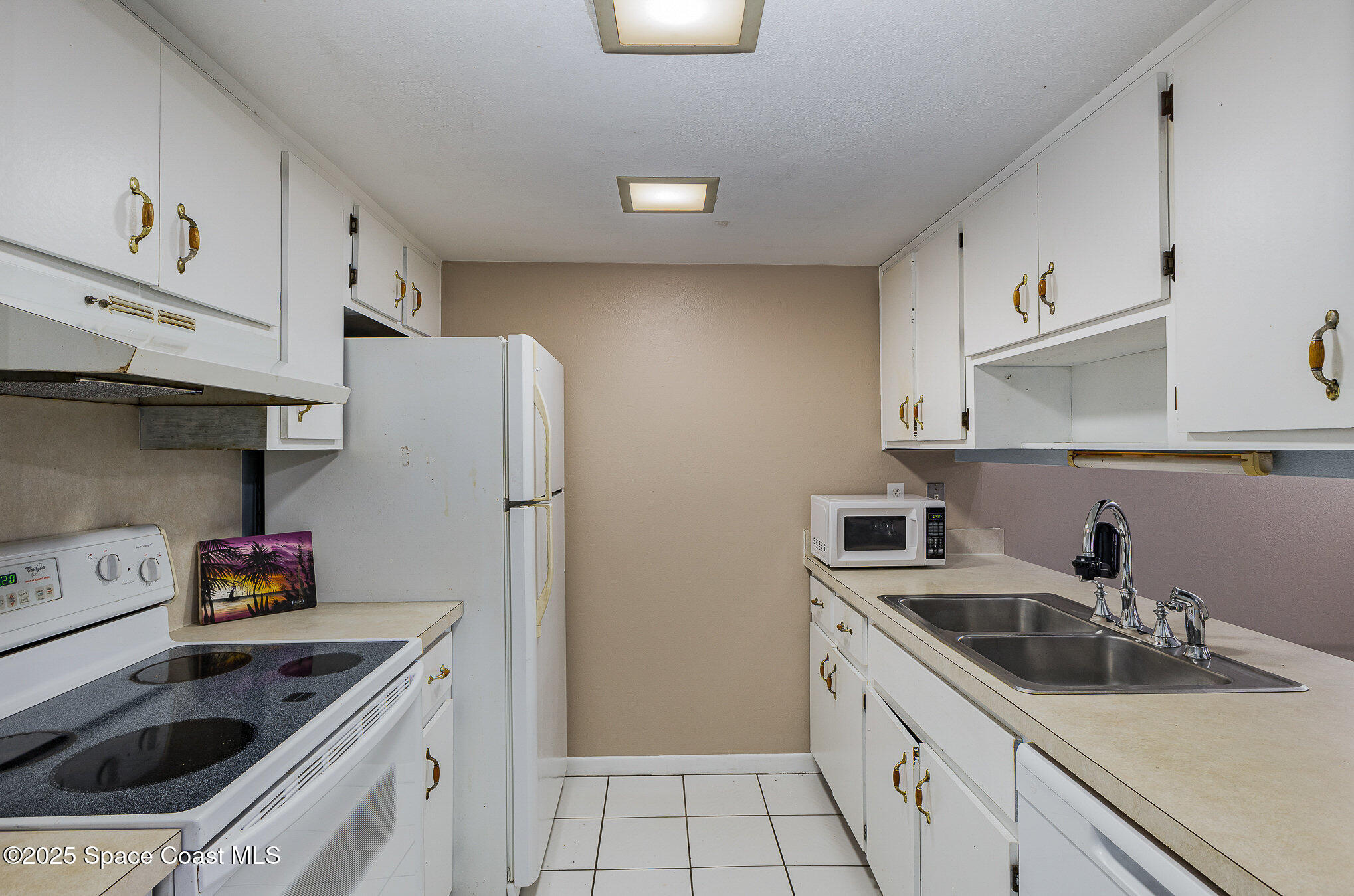 109 San Paulo Circle, Unit 15109 West Melbourne, FL 32904 - Photo 13 of 30 a kitchen with stainless steel appliances granite countertop a sink stove and refrigerator