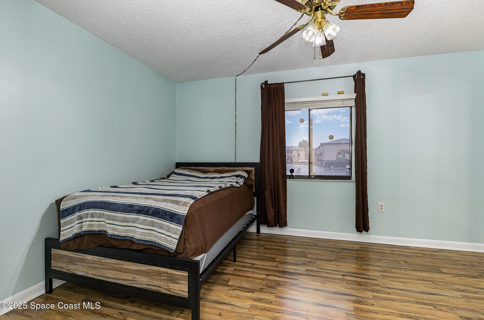 109 San Paulo Circle, Unit 15109 West Melbourne, FL 32904 - Photo 18 of 30 a bedroom with a bed and a chandelier