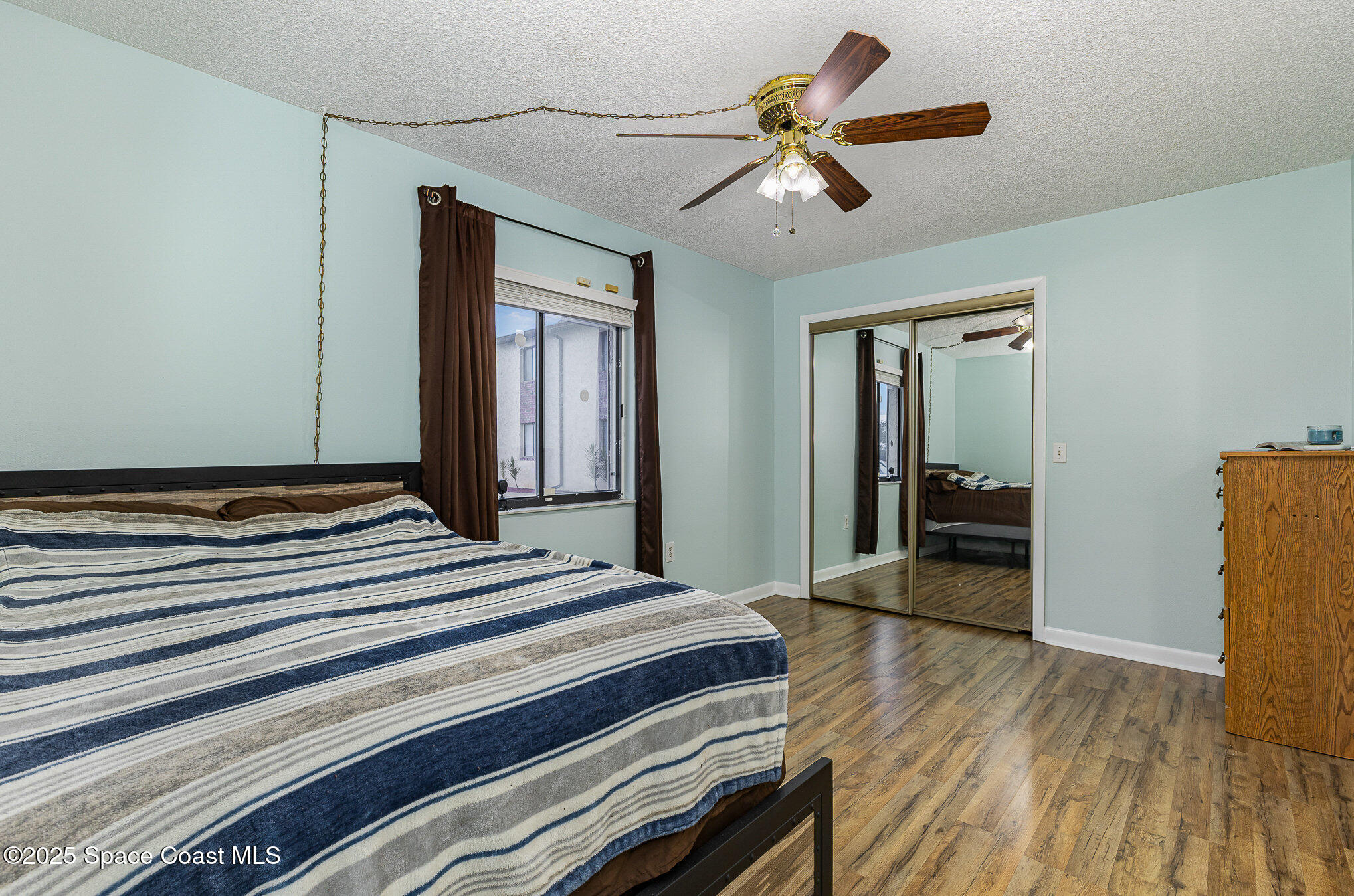 109 San Paulo Circle, Unit 15109 West Melbourne, FL 32904 - Photo 19 of 30 a bedroom with a bed and a chandelier