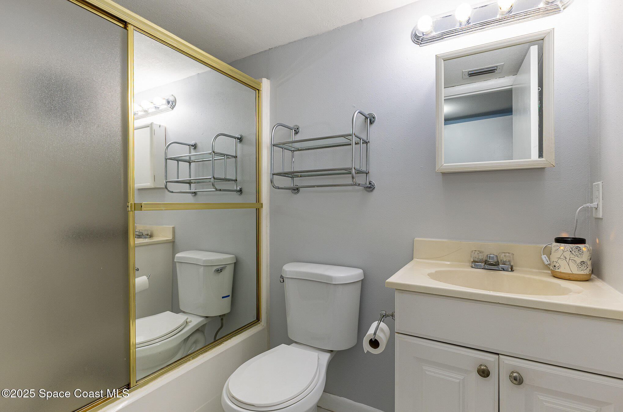109 San Paulo Circle, Unit 15109 West Melbourne, FL 32904 - Photo 21 of 30 a bathroom with a toilet sink vanity and mirror