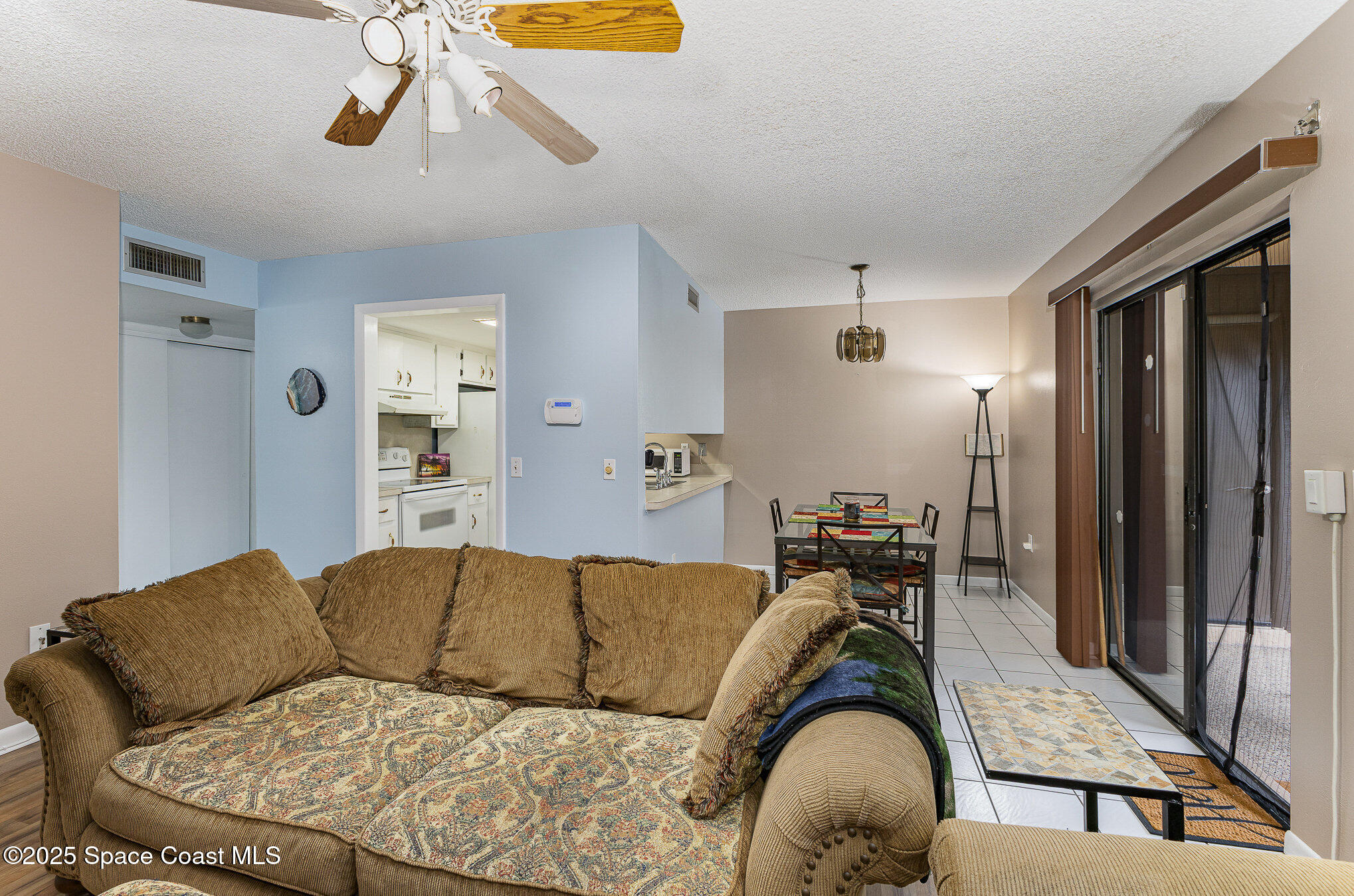 109 San Paulo Circle, Unit 15109 West Melbourne, FL 32904 - Photo 6 of 30 a living room with a couch and a chandelier