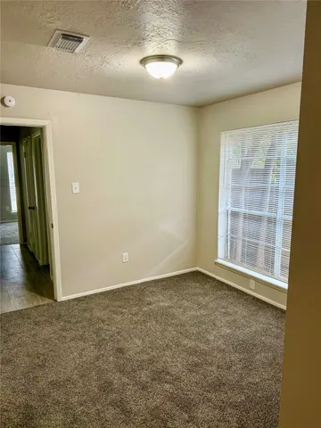 en empty room with windows and ceiling fan