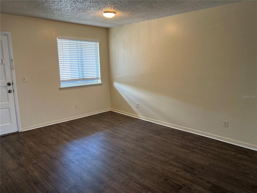 6312 Newtown Circle, Unit 12B3 Tampa, FL 33615 - Photo 4 of 10 an empty room with wooden floor and windows
