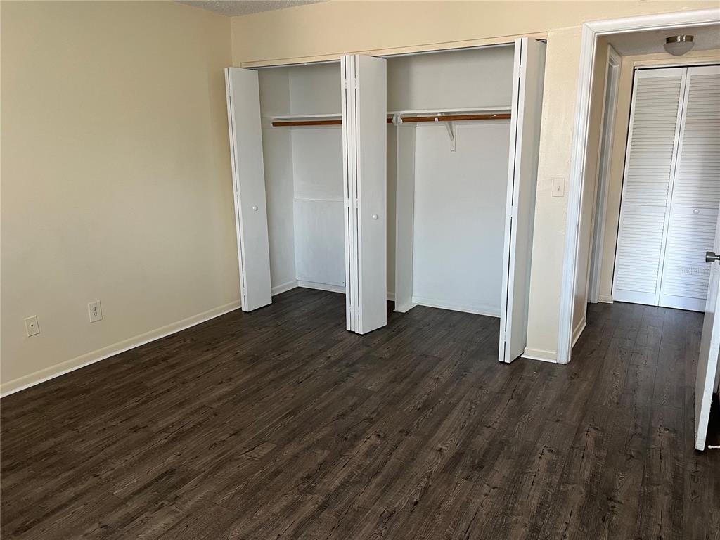 6312 Newtown Circle, Unit 12B3 Tampa, FL 33615 - Photo 5 of 10 an empty room with wooden floor & closet area