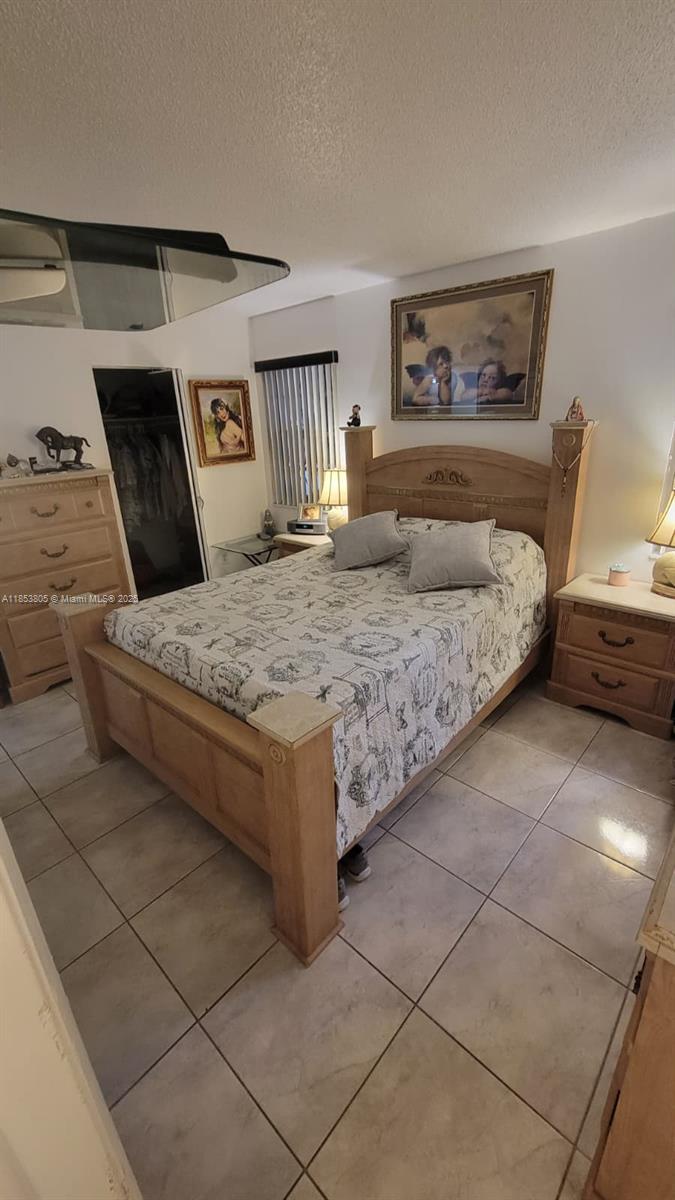 11472 Southwest 4th Street Sweetwater, FL 33174 - Photo 58 of 65 a bedroom with a bed and a night stand