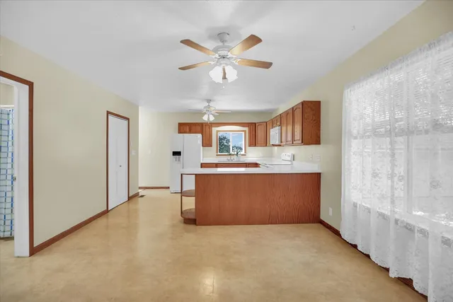 a large kitchen with stainless steel appliances a large counter top space and a chandelier