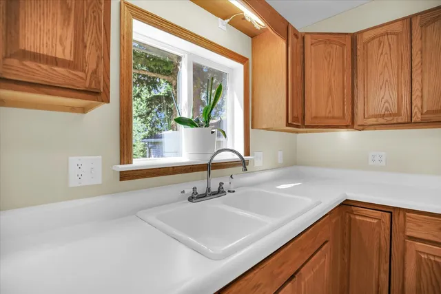a kitchen with a sink cabinets and a window