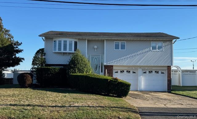 28 Harding Avenue Lindenhurst, NY 11757 - Photo 1 of 1 Raised ranch with concrete driveway, a garage, and brick siding