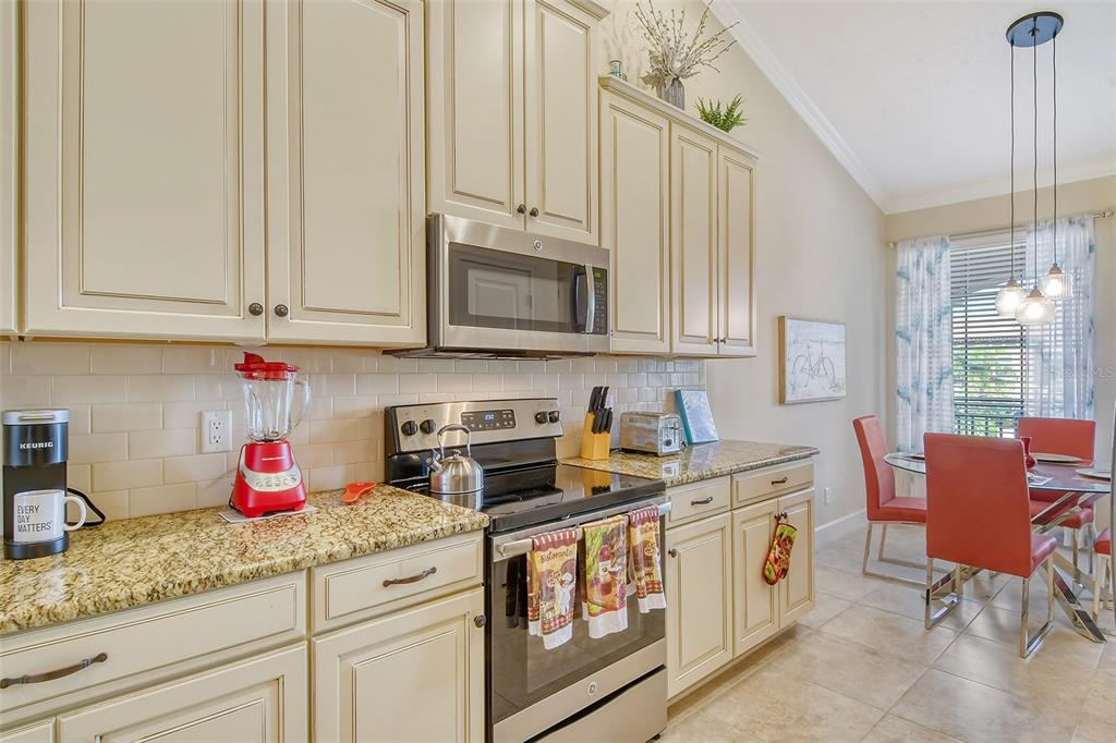 13604 Messina Loop, Unit 203 Bradenton, FL 34211 - Photo 14 of 56 a kitchen with stainless steel appliances granite countertop a sink stove and cabinets