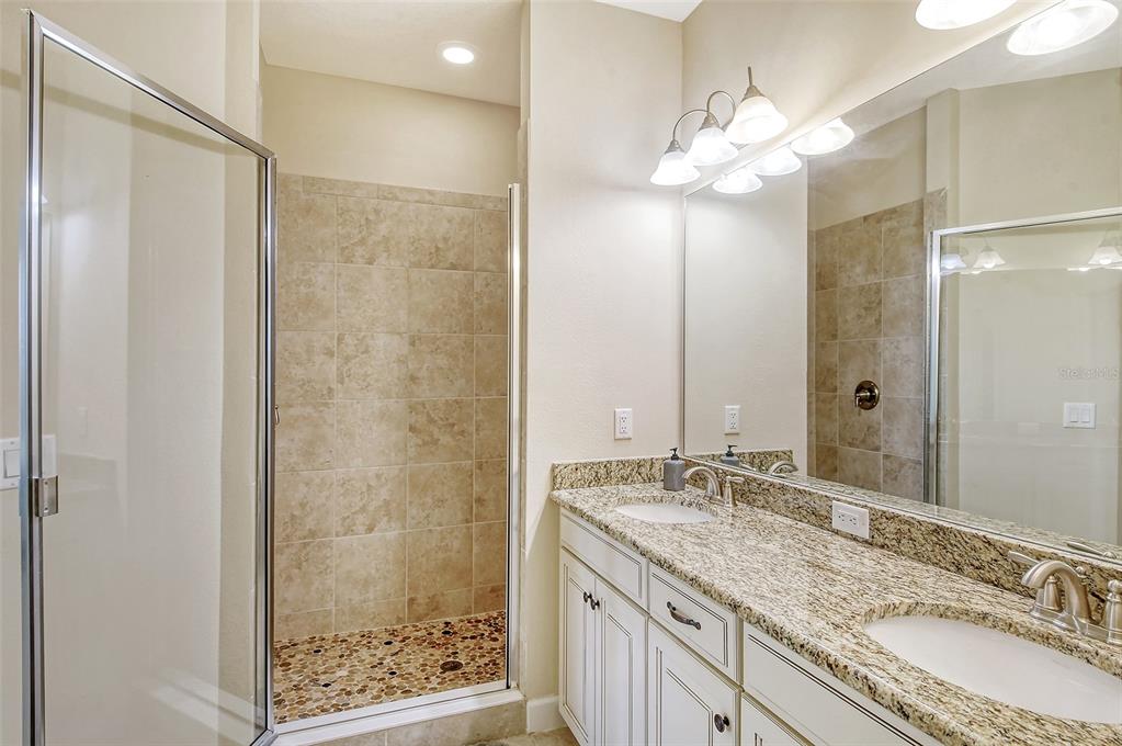 13604 Messina Loop, Unit 203 Bradenton, FL 34211 - Photo 23 of 56 a bathroom with a granite countertop sink mirror and a shower